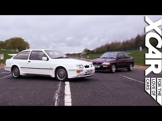 Vit Ford Sierra RS Cosworth framför en mörkröd sportbil på en väg