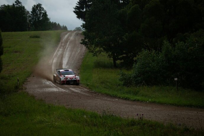 Rallybil sladdar på en lerig skogsväg och virvlar upp damm